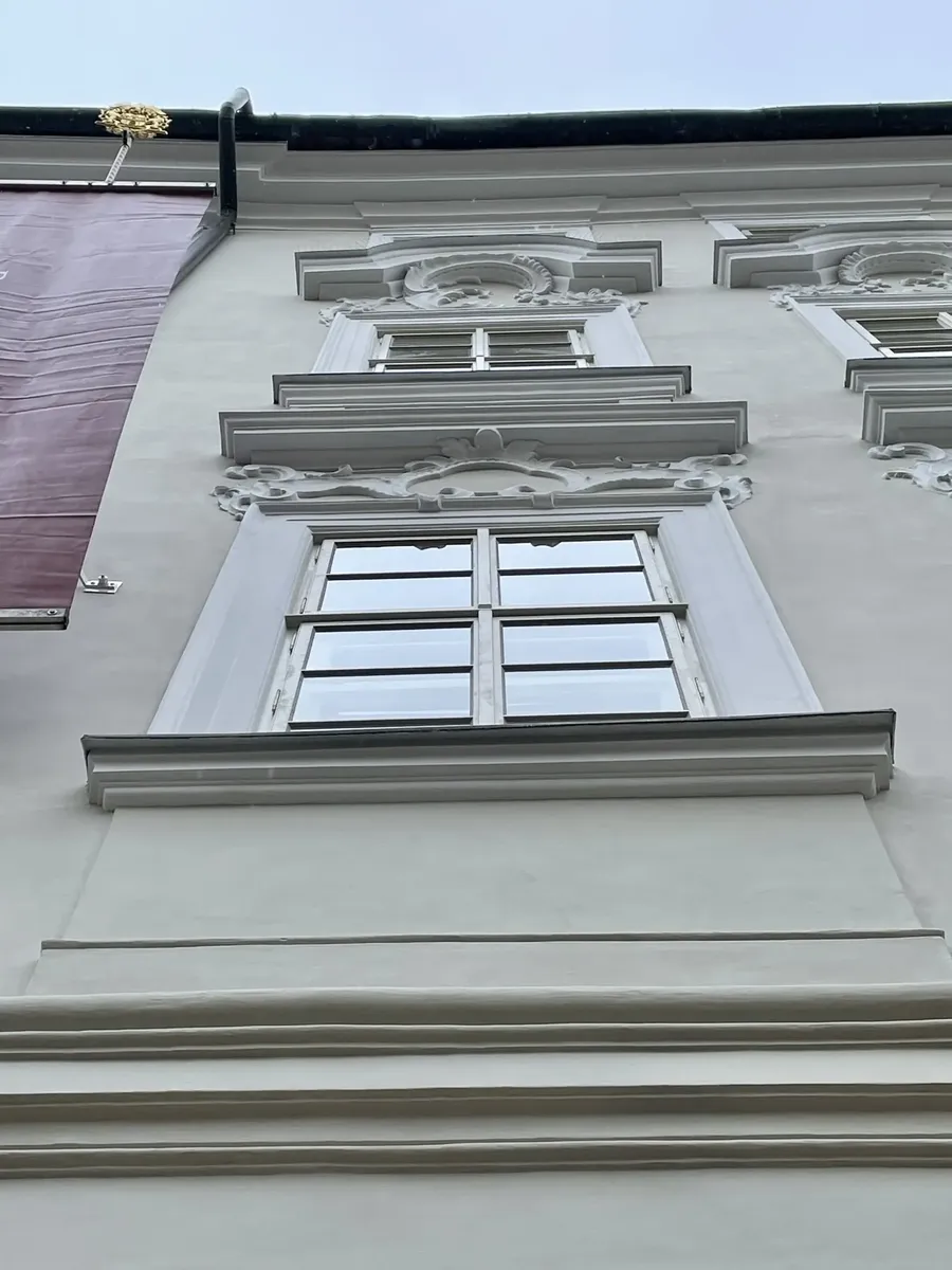 Bílá špaletová okna v historickém kamenném ostění