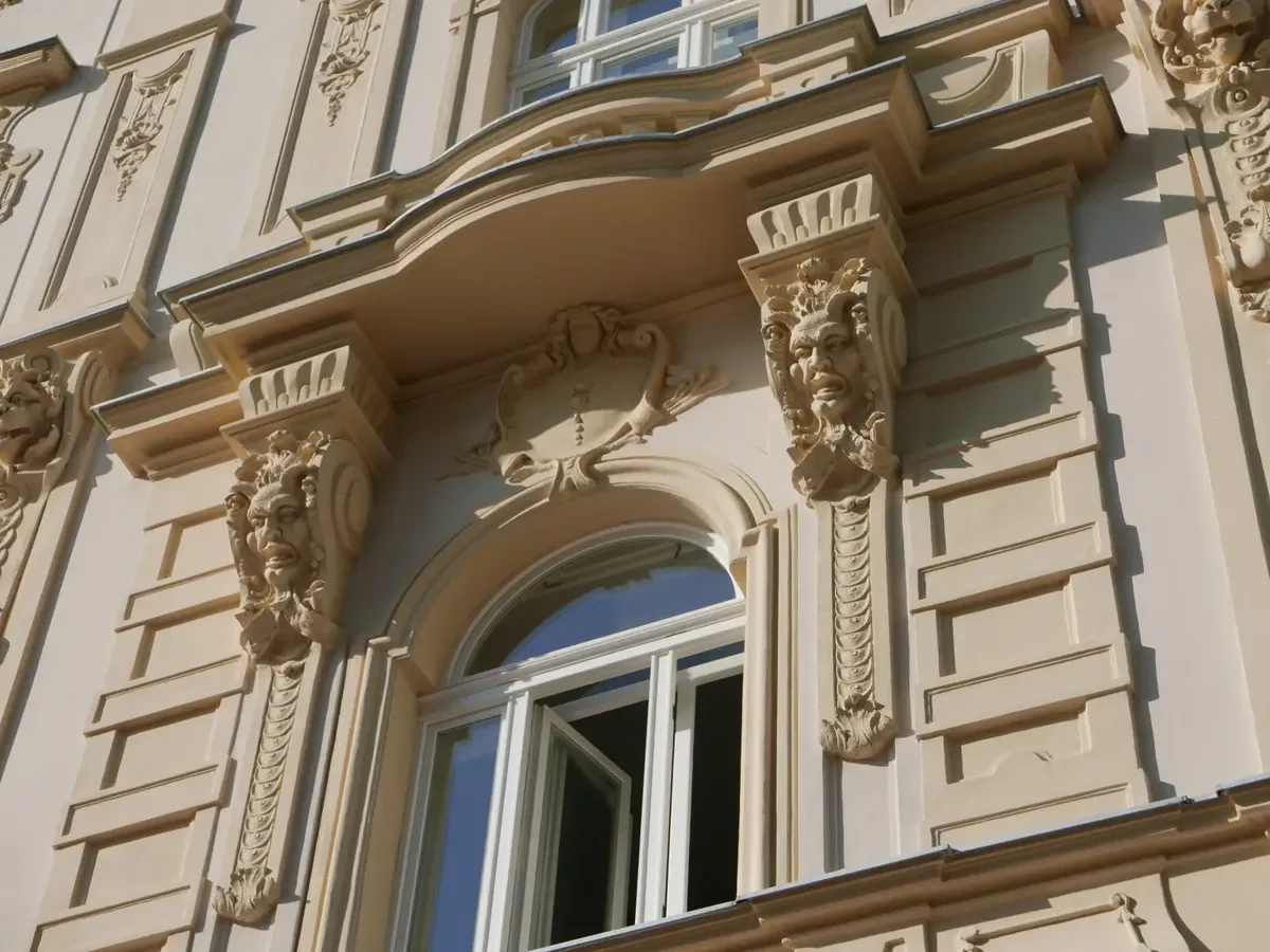 Pootevřené špaletové okno s dekorativním klenutím